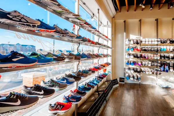Large windows and extensive shoe wall inside Fleet Feet Decatur Atlanta retail space.