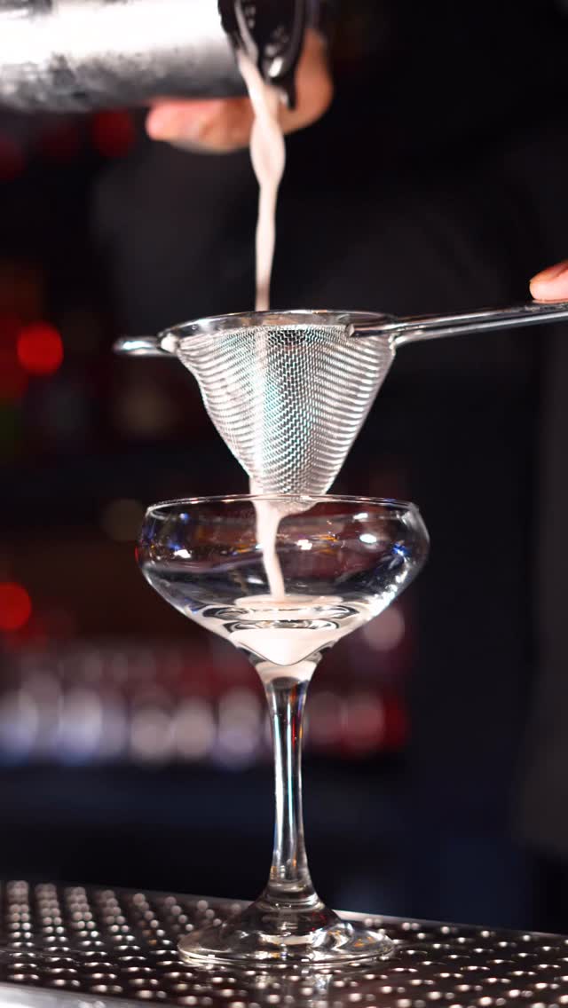 Cocktail being double strained into a coupe glass at Beso Buckhead Atlanta.