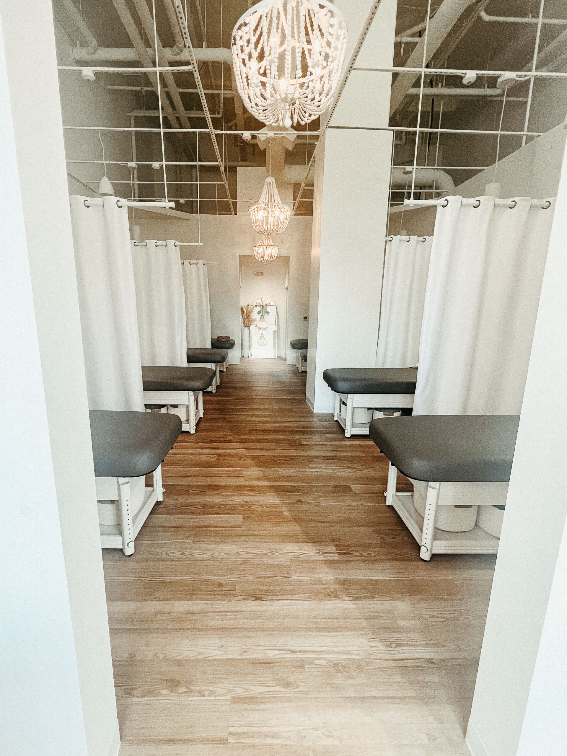 Modern lobby with wood staircase and woven pendant at FACE FOUNDRIÉ Charleston – Mount Pleasant.