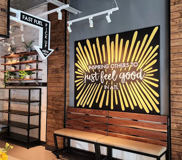 Wooden bench in front of yellow fry-shaped mural inside Original ChopShop Buckhead Atlanta.