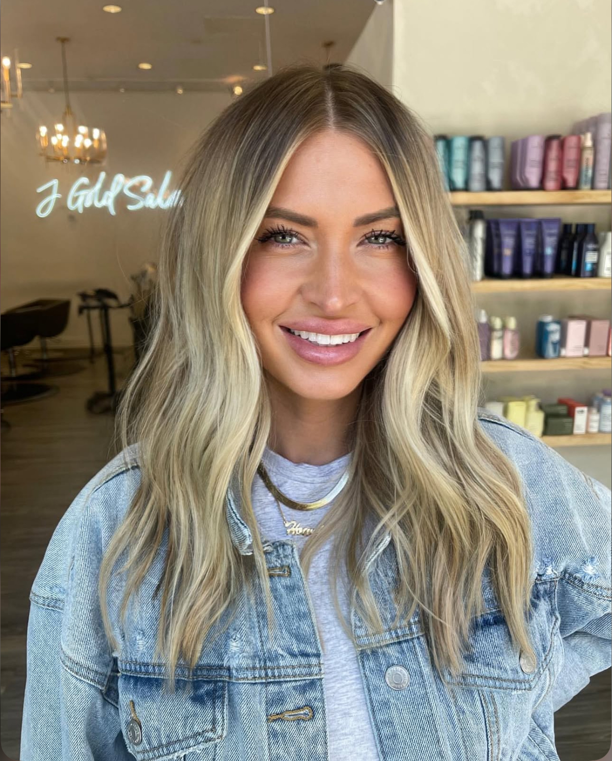 Guest with beachy blonde balayage and money-piece highlights smiling at J Gold Salon Atlanta.