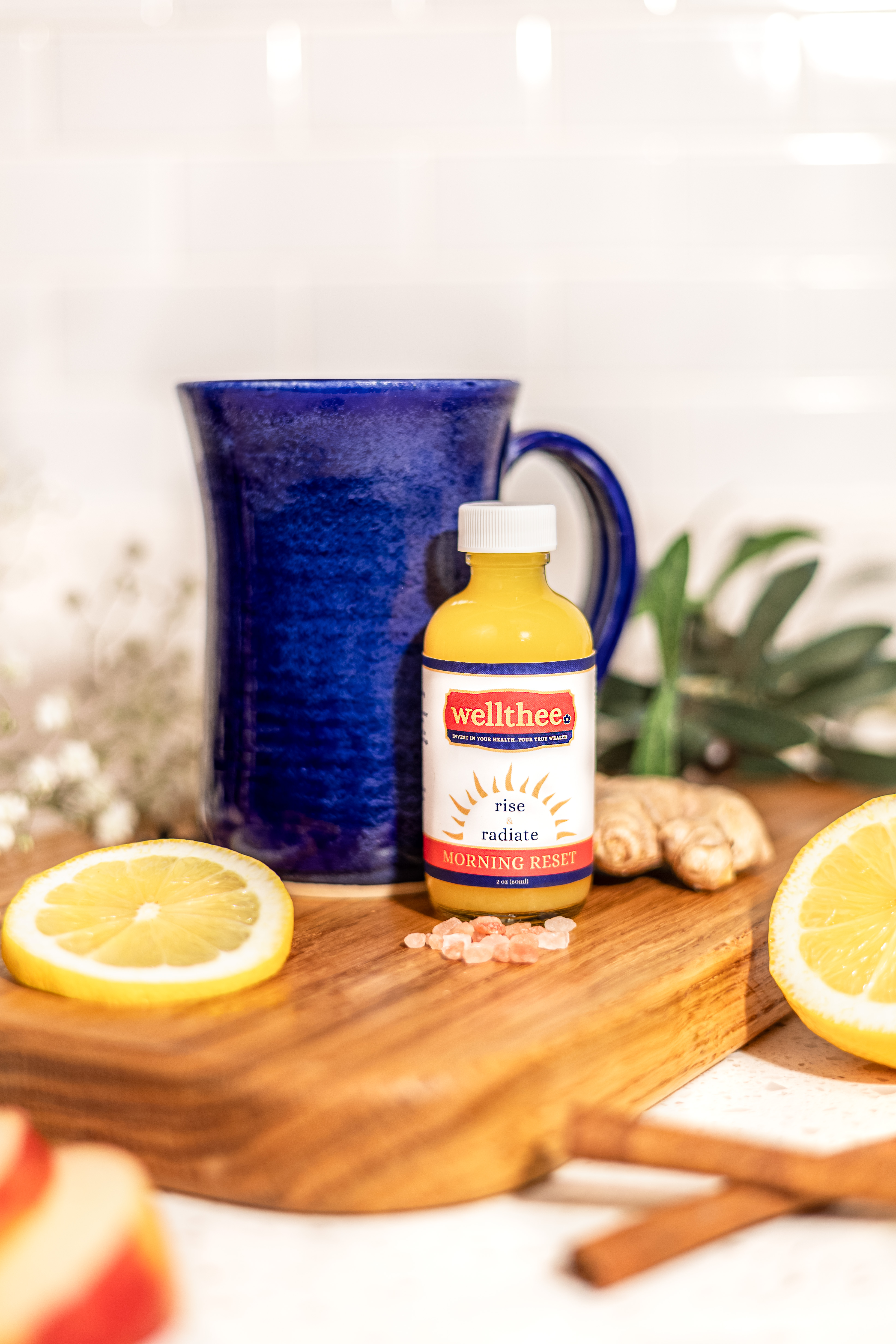 Morning Reset bottle, blue mug and citrus slices on a wooden board