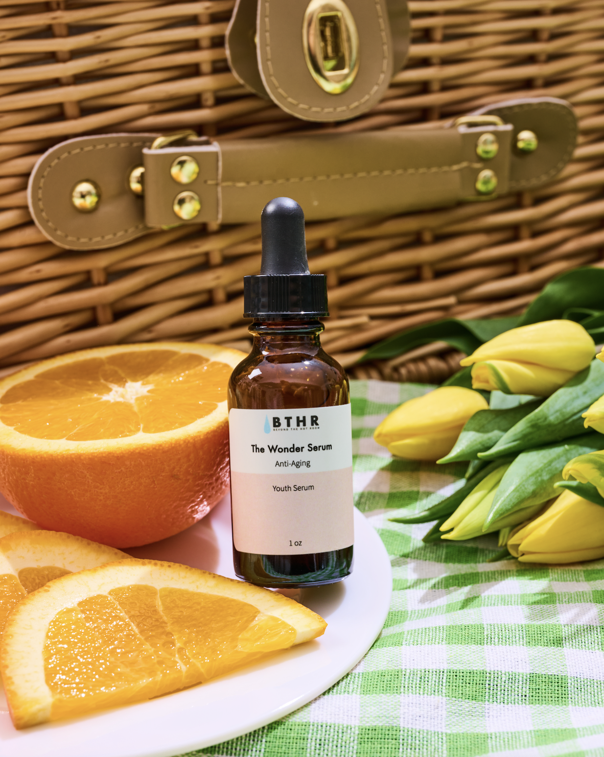 BTHR The Wonder Serum Youth Serum dropper bottle styled with fresh oranges on a picnic basket