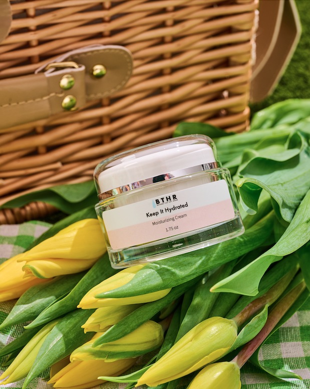 BTHR Keep It Hydrated Moisturizing Cream jar next to yellow tulips and a wicker basket
