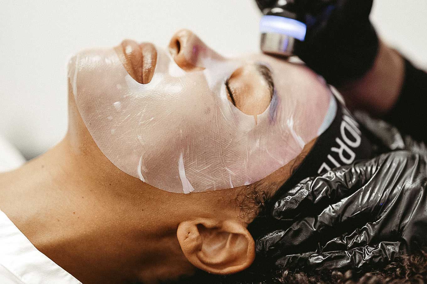 Close-up of hydrating mask and LED light panel during facial at FACE FOUNDRIÉ Charleston – Mount Pleasant.