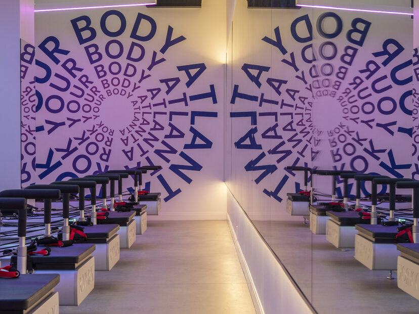 Corridor lined with repeating BODY text and mirrors guiding guests at BODYROK Inman Park Atlanta.