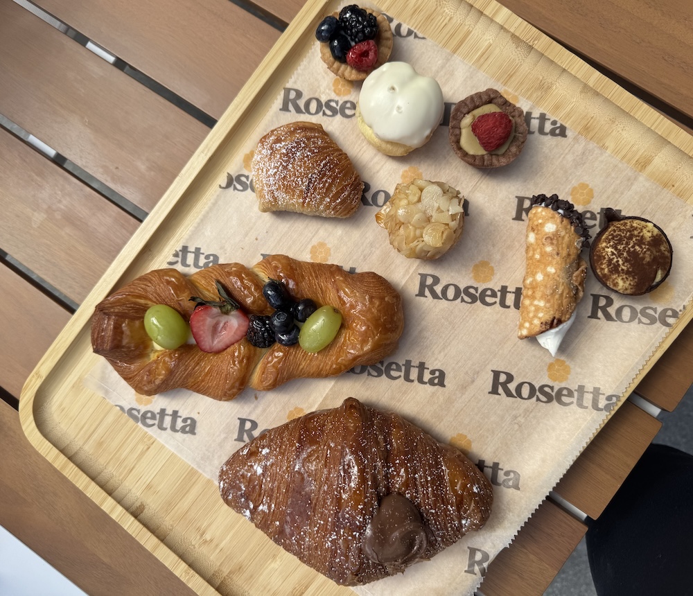 Wooden charcuterie and pastry board with Rosetta-branded cup.