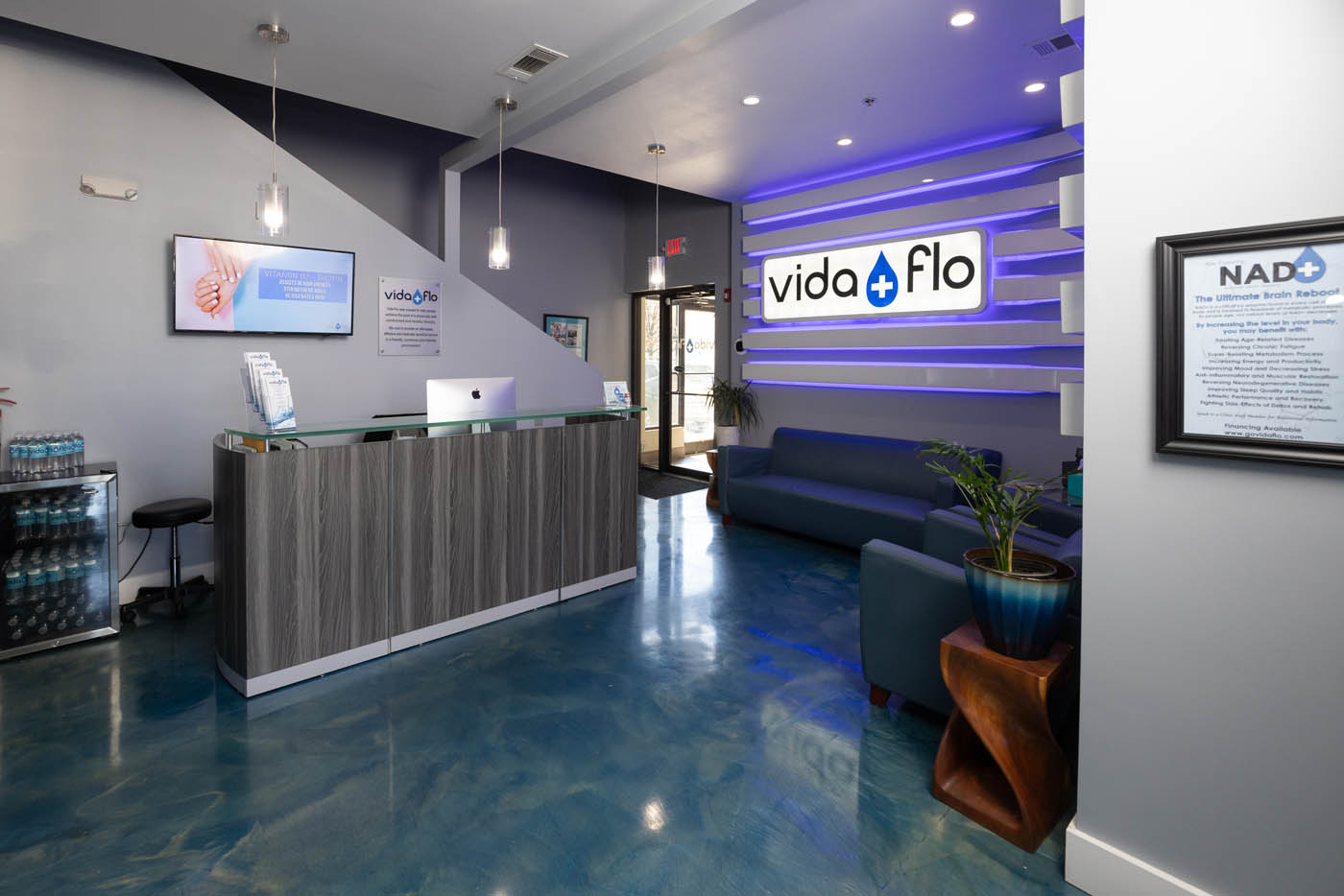 Grey reception counter and blue floor inside Vida-Flo Town Brookhaven Atlanta clinic.