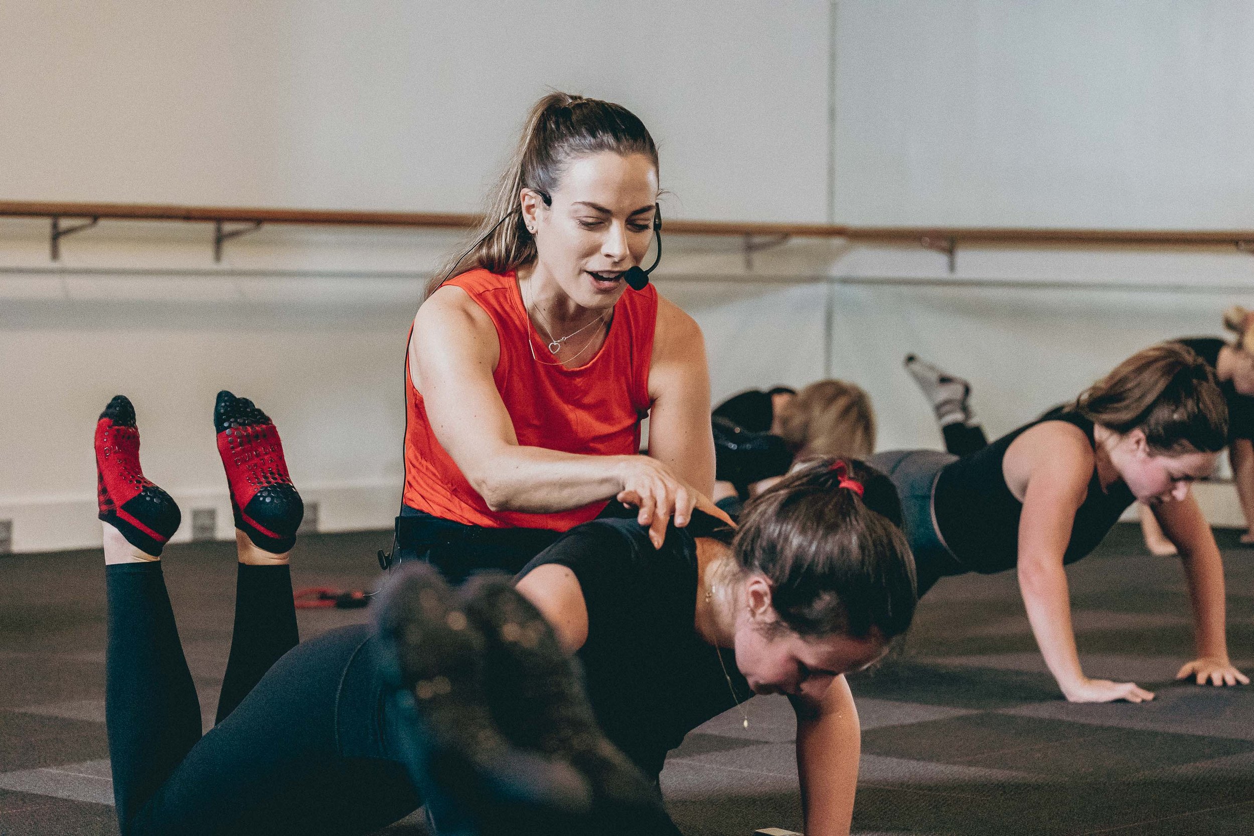 Instructor assisting client with form during class at Pure Barre Charleston Downtown