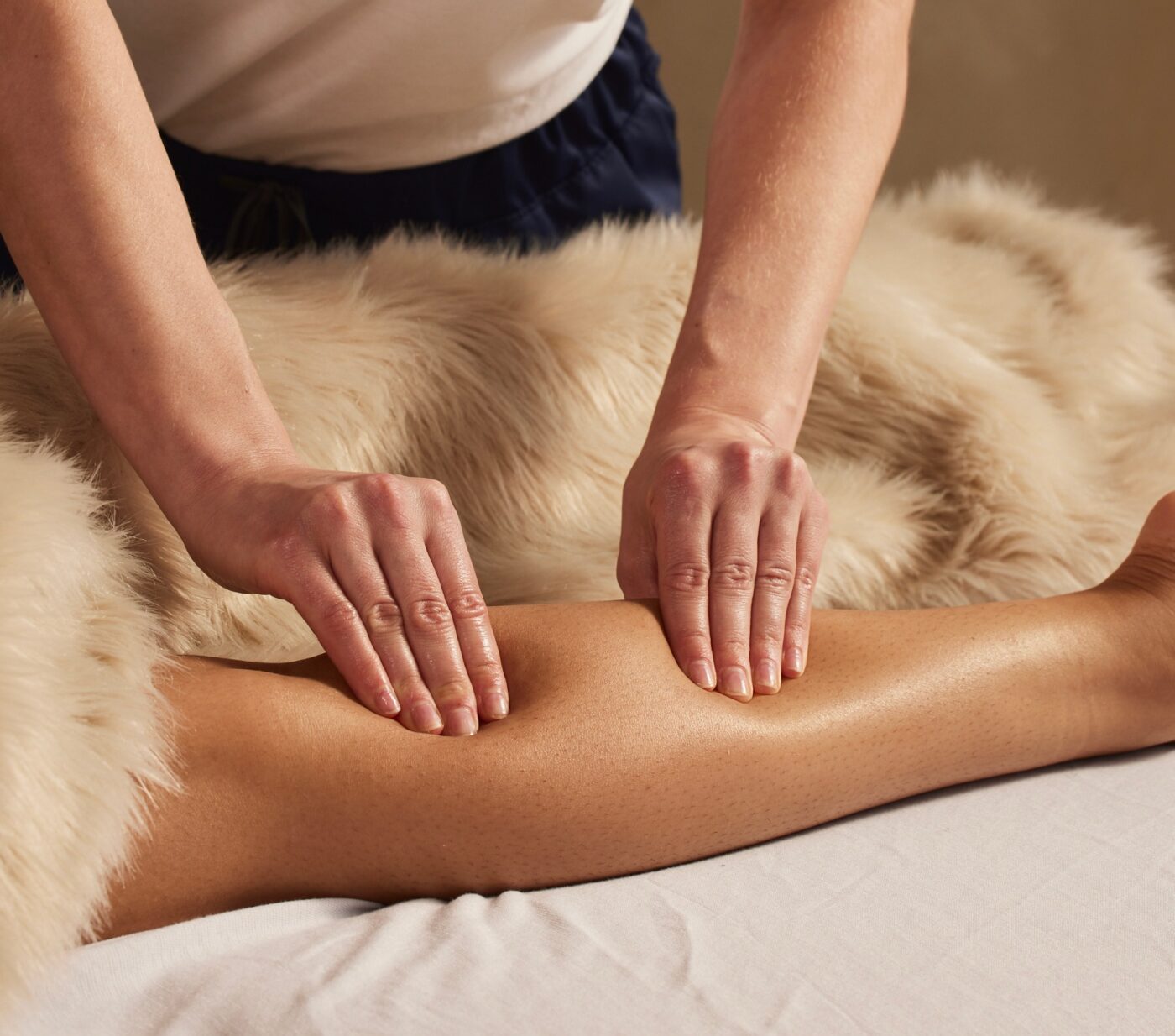 Therapist giving a relaxing forearm massage on a faux-fur table at The NOW Massage Mount Pleasant.