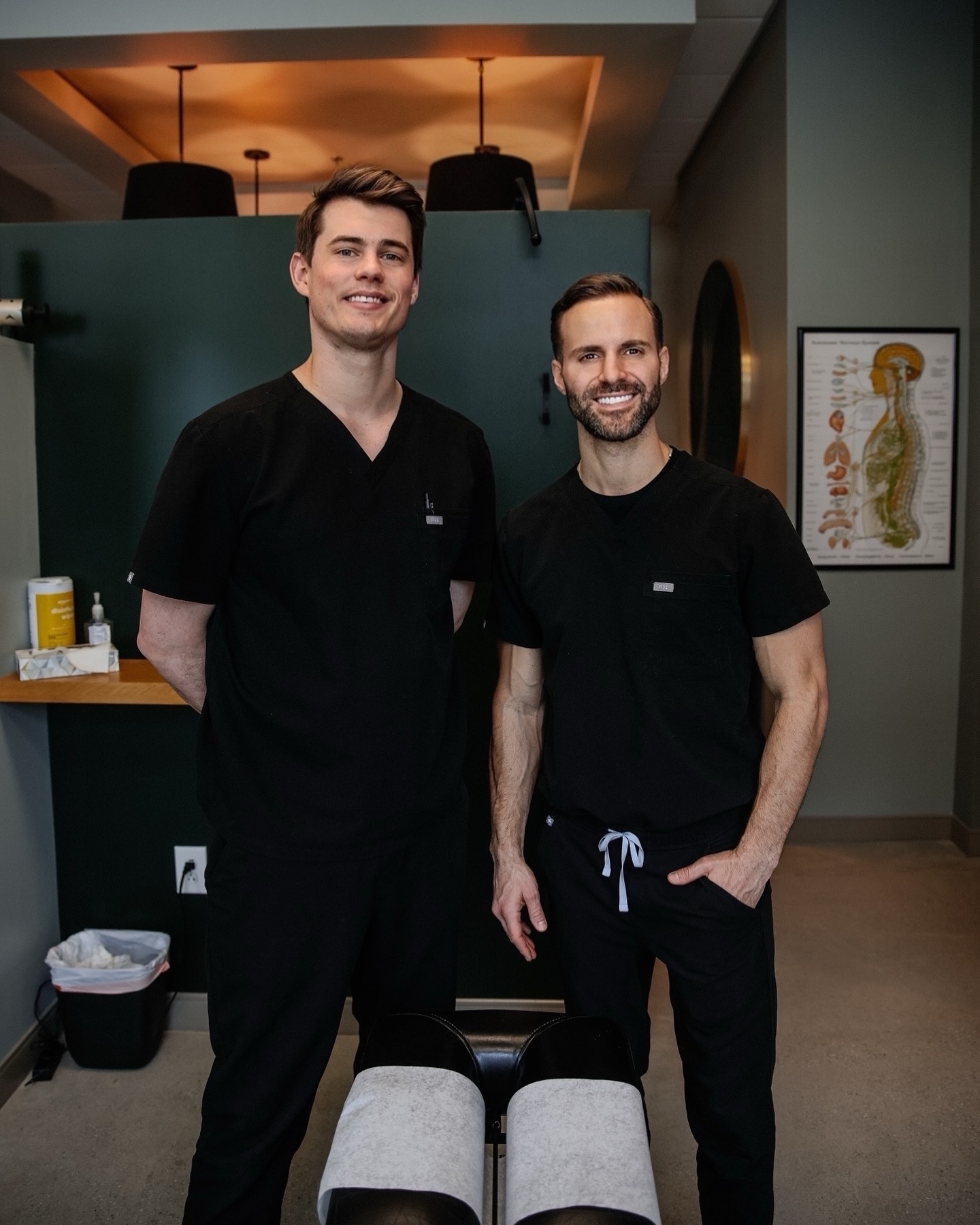 Two chiropractors smiling inside Taylor Chiropractic Inman Park clinic.
