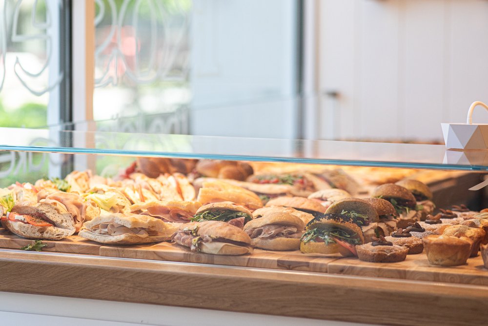 Golden croissants and pastries in glass display at bakery.