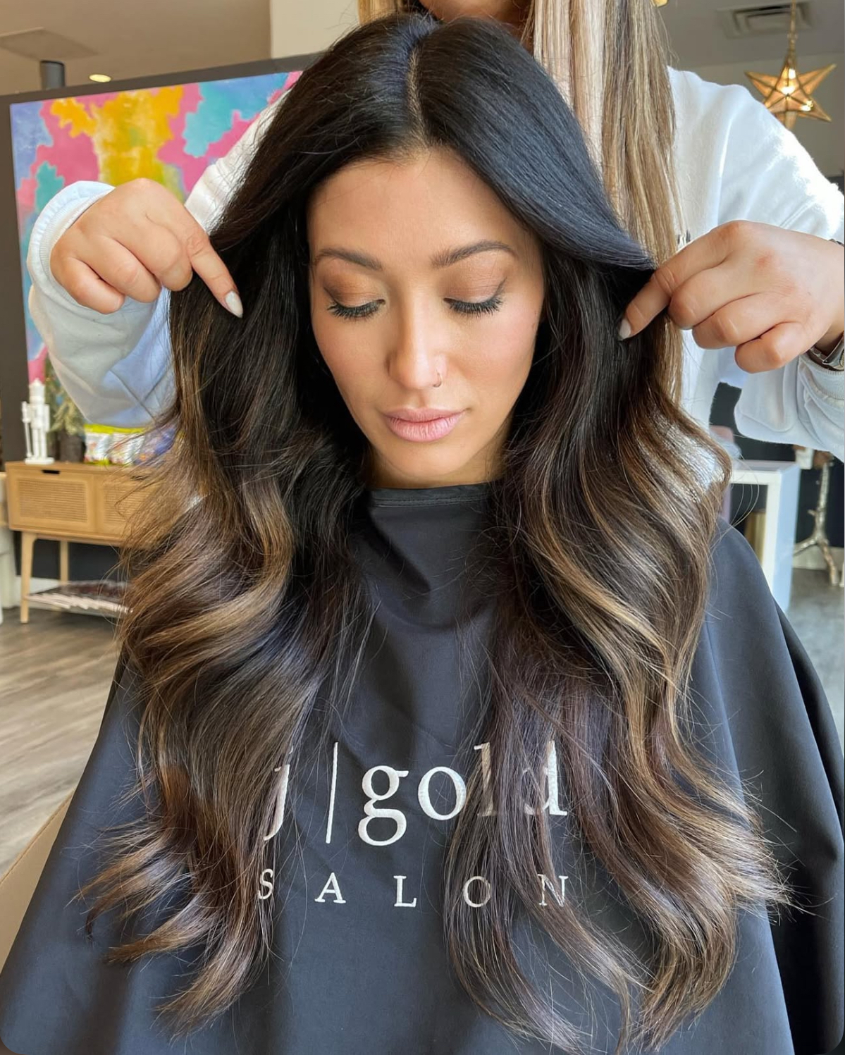 Stylist fingers comb rich espresso curls on client at J Gold Salon Atlanta.