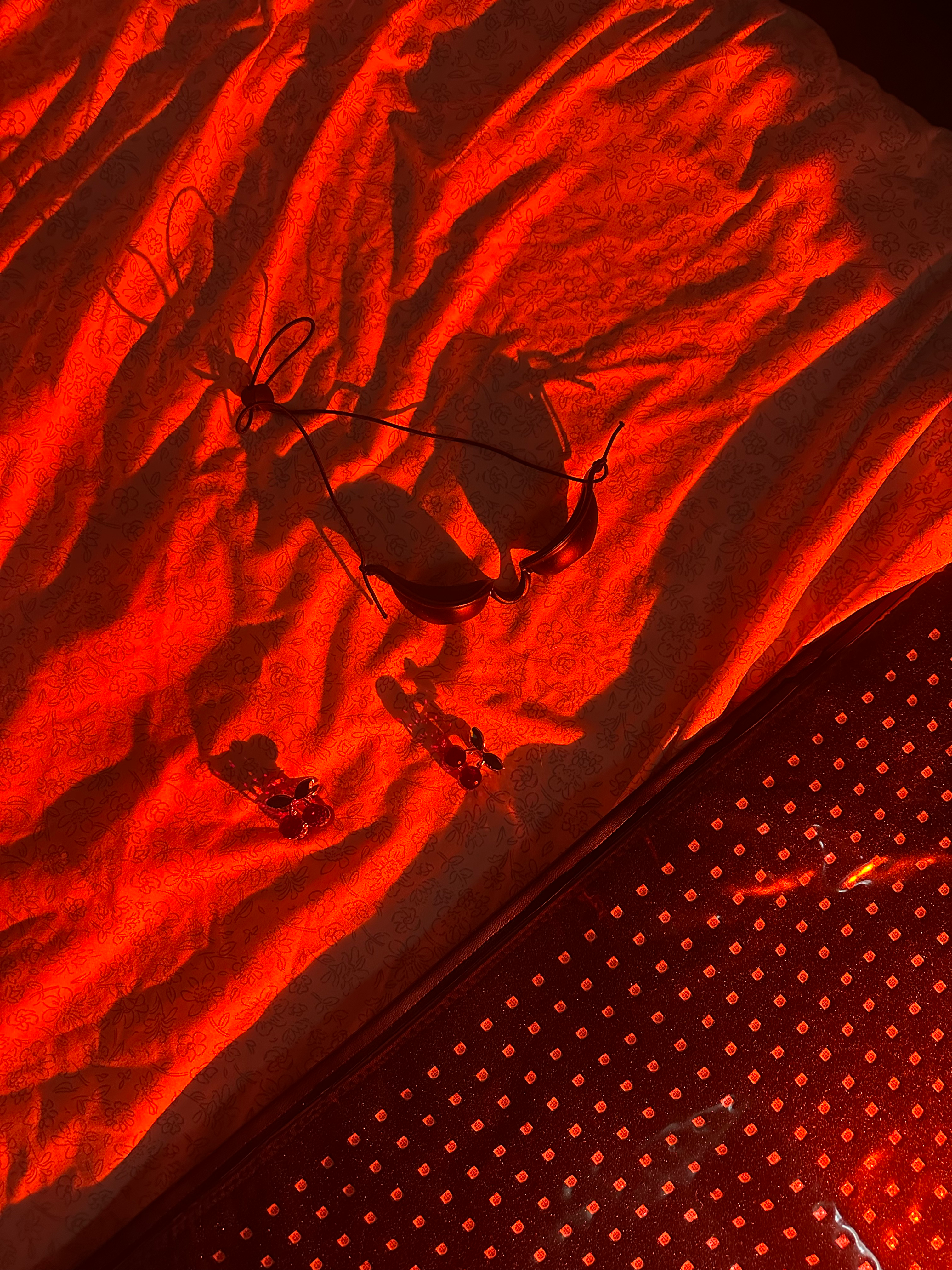Close-up of red fabric textured under therapy light.