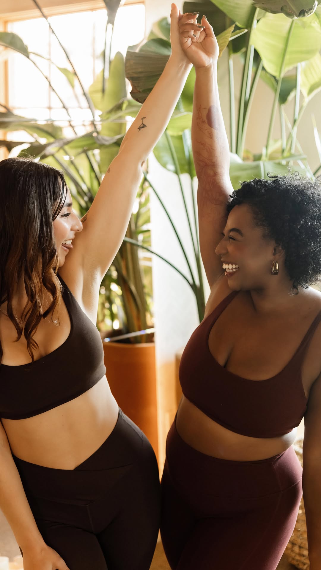 Two women high-fiving during class at Jungle Studio Dallas