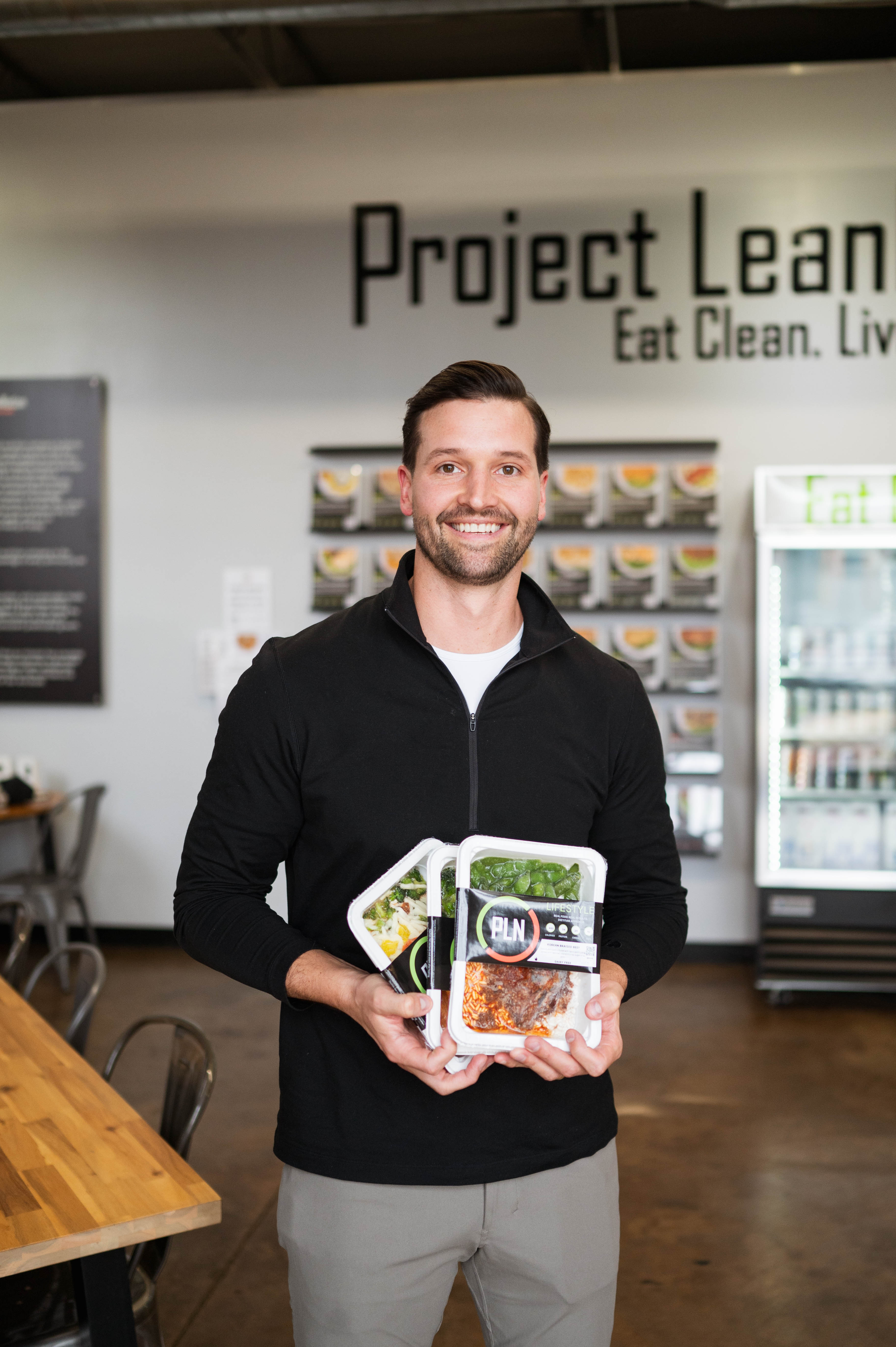 Man holding open meal containers inside Project LeanNation South End Charlotte.