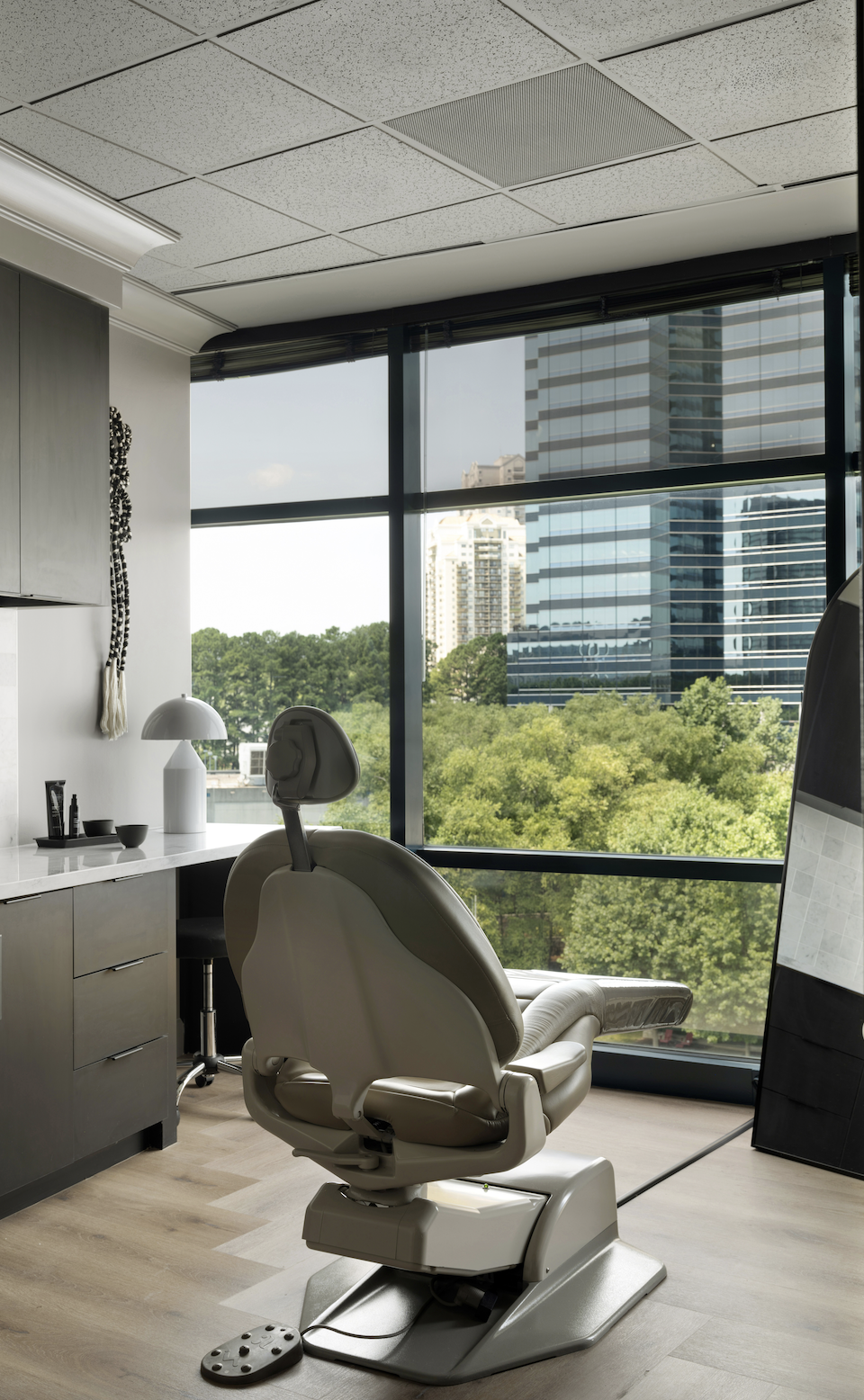 Treatment chair facing Atlanta skyline in a bright room at CULT Aesthetics Atlanta clinic.