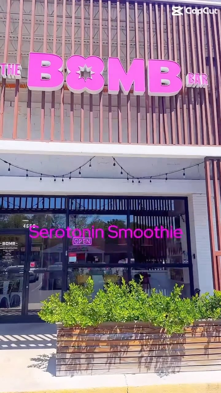 Exterior shot of Bomb Bar storefront with pink-striped wall and sign.