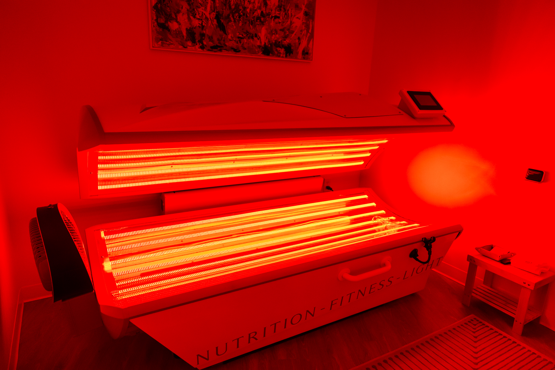 Full-body red-light therapy bed glowing red at Rest + Fuel Buckhead Atlanta