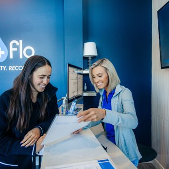Nurse and client discuss IV therapy options at consultation desk inside Vida-Flo Town Brookhaven Atlanta.