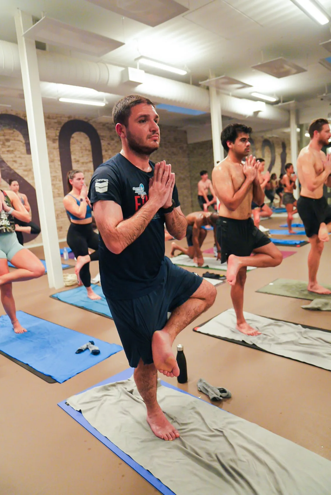 Lead instructor with mic coaches students during power yoga at ISO Yoga Atlanta.
