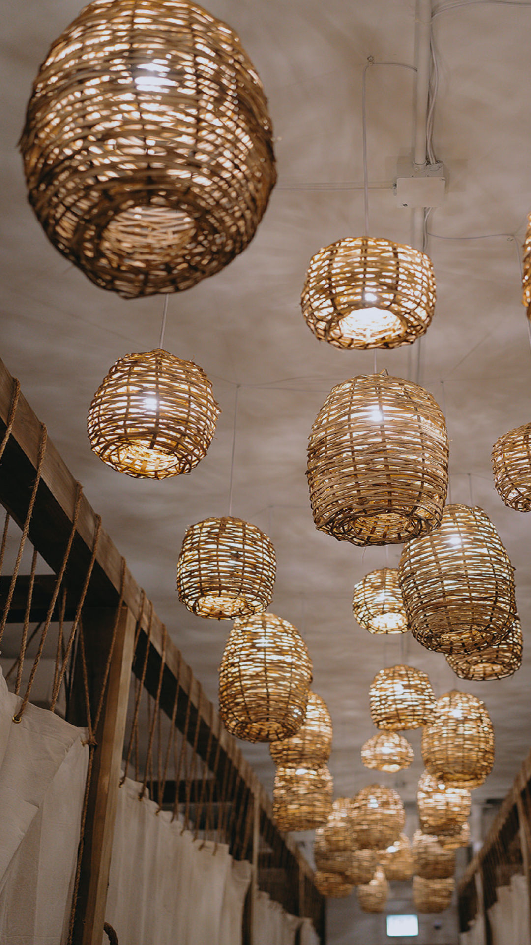Woven basket pendant lights hanging in hallway at The NOW Massage Mount Pleasant.