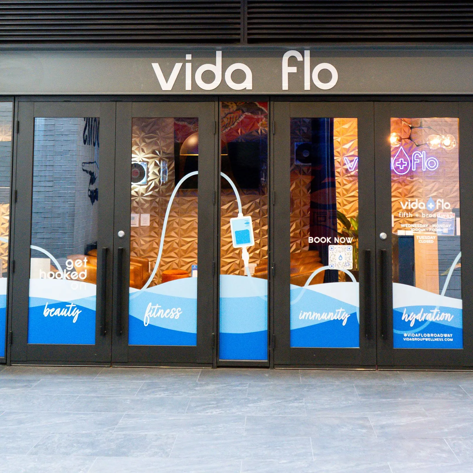 Exterior glass storefront with Vida-Flo decals at West Midtown Atlanta location.