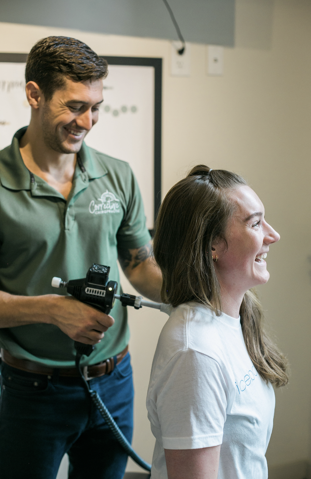 Chiropractor performing a seated neck adjustment on a female patient.