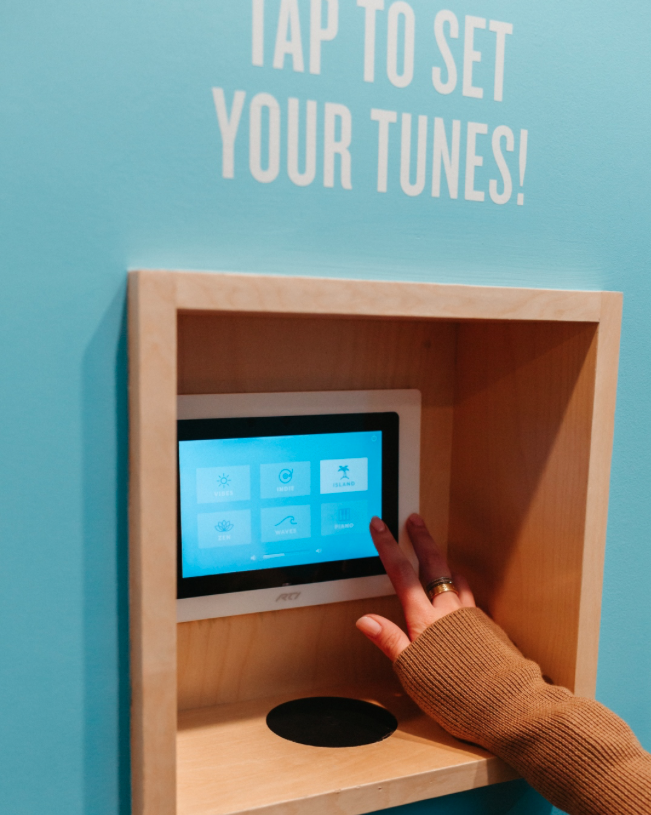 Touchscreen music controls in a massage room at Squeeze Charlotte Park Road
