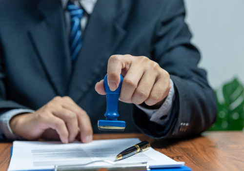 A bank manager holds a stamp over paperwork