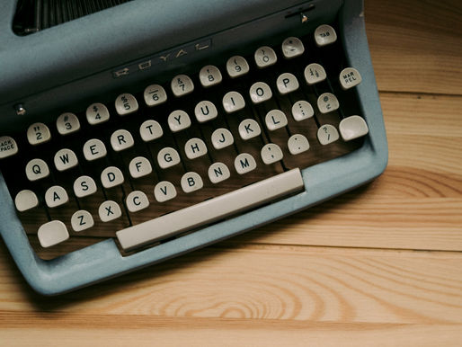A typewriter on a wooden table.