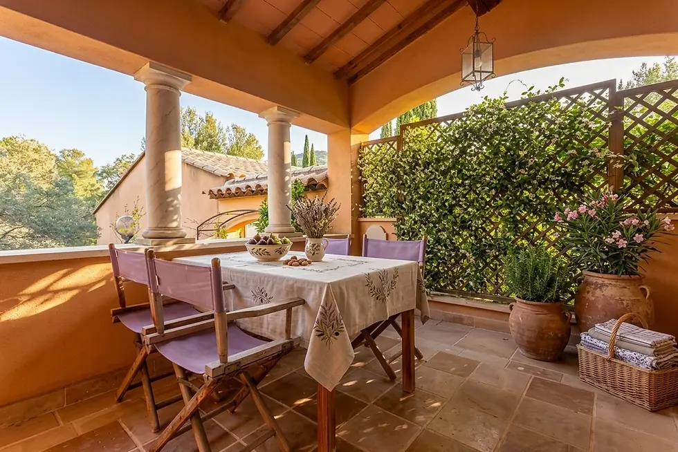 Table set with a Provençal tablecloth under a covered terrace