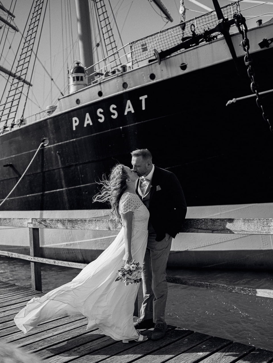 Ein strahlendes Brautpaar steht Hand in Hand vor der historischen Kulisse des Lübecker Rathauses. Der Hochzeitsfotograf in Lübeck und Umgebung hat den perfekten Winkel gefunden, um das glückliche Paar vor dem imposanten Gebäude abzulichten. Der Fotograf fängt die Freude und Liebe des Tages in jedem Bild ein und schafft damit einzigartige Erinnerungen für das Paar und ihre Familie. Ob beim romantischen Paarshooting in einem der idyllischen Gärten der Stadt oder beim Festhalten der festlichen Stimmung auf der Feier, der Fotograf sorgt dafür, dass jedes Detail des Tages unvergesslich bleibt. Mit seinem professionellen Service und seiner Leidenschaft für die Fotografie ist er der ideale Begleiter für jeden, der in Lübeck und Umgebung heiratet und eine Hochzeit in Bildern festhalten möchte, die für immer Bestand haben werden.