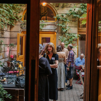 Parents mingling in the courtyard at Brody House during REAL Impact Night 2025.