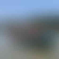 Four REAL School Budapest students in orange life jackets paddle a canoe on a wide river with paddles raised during the REAL Beginnings Adventure, the school's annual rite-of-passage trip held at the start of the year.