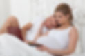 Happy pregnant family with notebook lies on the house bed..jpg