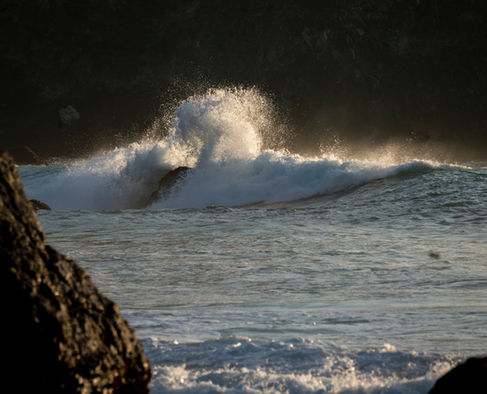 Waves crashing against rocks in the ocean.