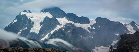 Snow-capped mountains under a cloudy sky.