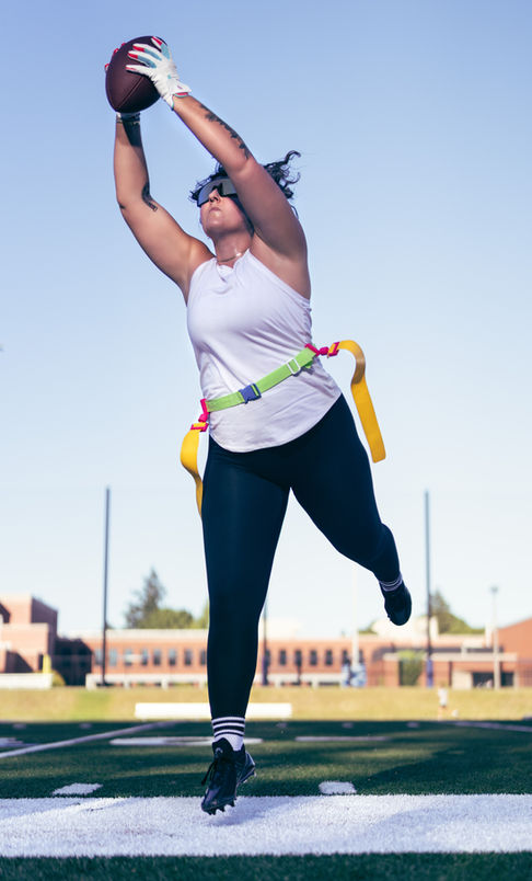 Person jumping with harness outdoors, wearing athletic clothing.
