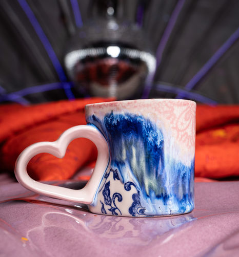 Mug with heart-shaped handle and blue wave design.