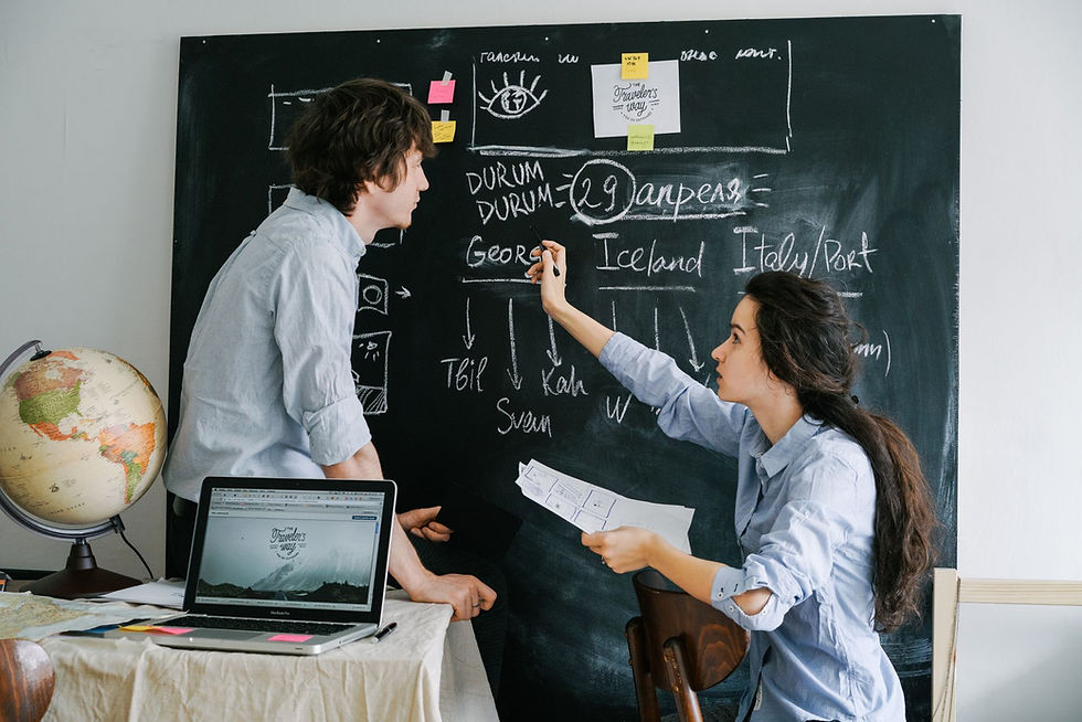 Couple planning their holiday itinerary together with a laptop, globe and chalkboard – why book with an independent travel agent
