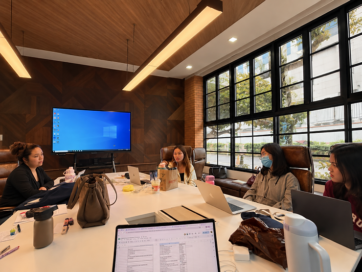 The team collaborating on their presentation strategy during a brainstorming session in the boardroom, synthesizing research, refining ideas, and finalizing their proposal.