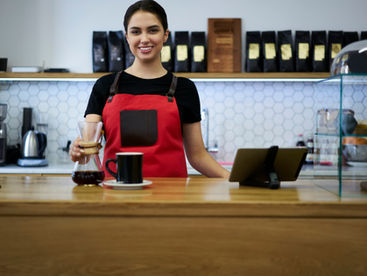 A barista brewing coffee behind the counter