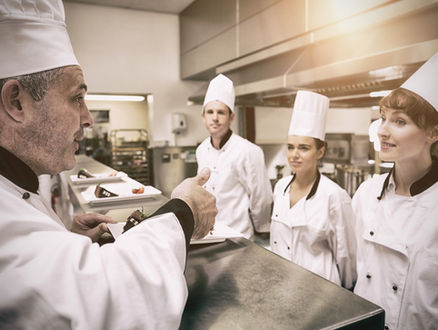Culinary students listen to their chef instructor