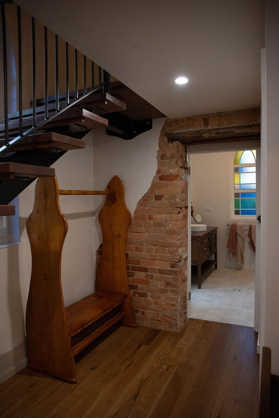 Arched windows, exposed convict made bricks and original tallowwood timber floors with a staircase on the left