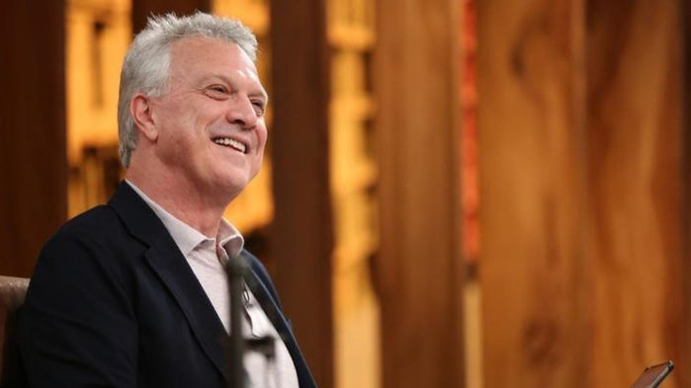Pedro Bial sorridente na bancada do Talk Show.