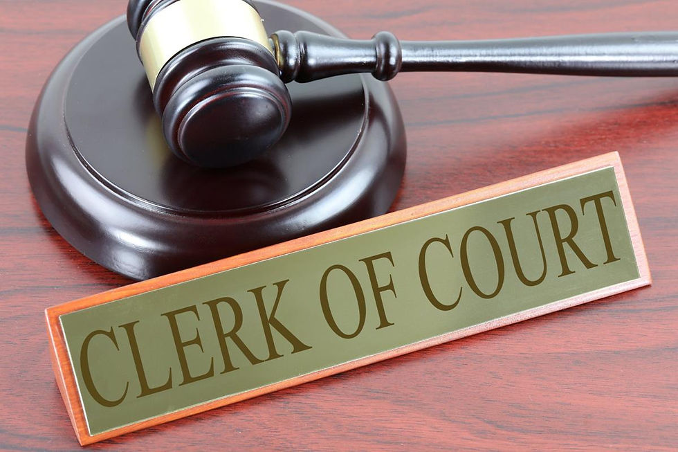A nameplate reading Clerk of the Court sits on a desk next to a judge's gavel.