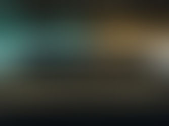 Uma fotografia conceitual surrealista com iluminação dramática, mostrando dois executivos em trajes corporativos sóbrios isolados nas bordas opostas de um abismo profundo de granito negro. O executivo da esquerda grita, visualizado como ondas sonoras fragmentadas de azul-petróleo e flashes dourados de amarelo-mostarda, que se transformam em partículas geométricas caindo no vazio. Do outro lado, a executiva cobre os ouvidos. Acima, em tipografia limpa, o texto branco lê: 'COMUNICAÇÃO HUMANIZADA NÃO É GENTILEZA.' e abaixo: 'É ESTRATÉGIA.'