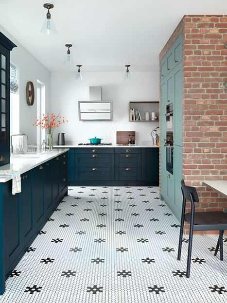 Shaker kitchen with Marine and Light Teal cabinetry, exposed brick wall, glass cabinets, and patterned black-and-white floor tiles.