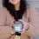 Thumbnail: A woman with her arms stretched out holding a scented soy wax candle that reads Burial Grounds of Historic New England